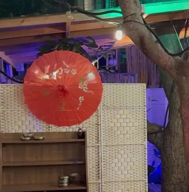 שמשיית נייר אדומה על רקע מחיצת קש